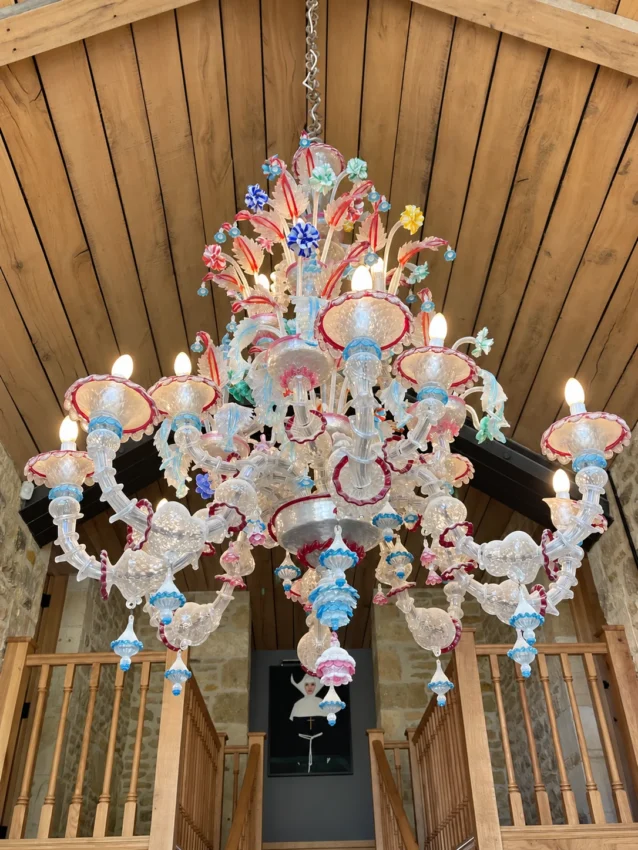 Decorative chandelier with coloured glass flowers and scrollwork