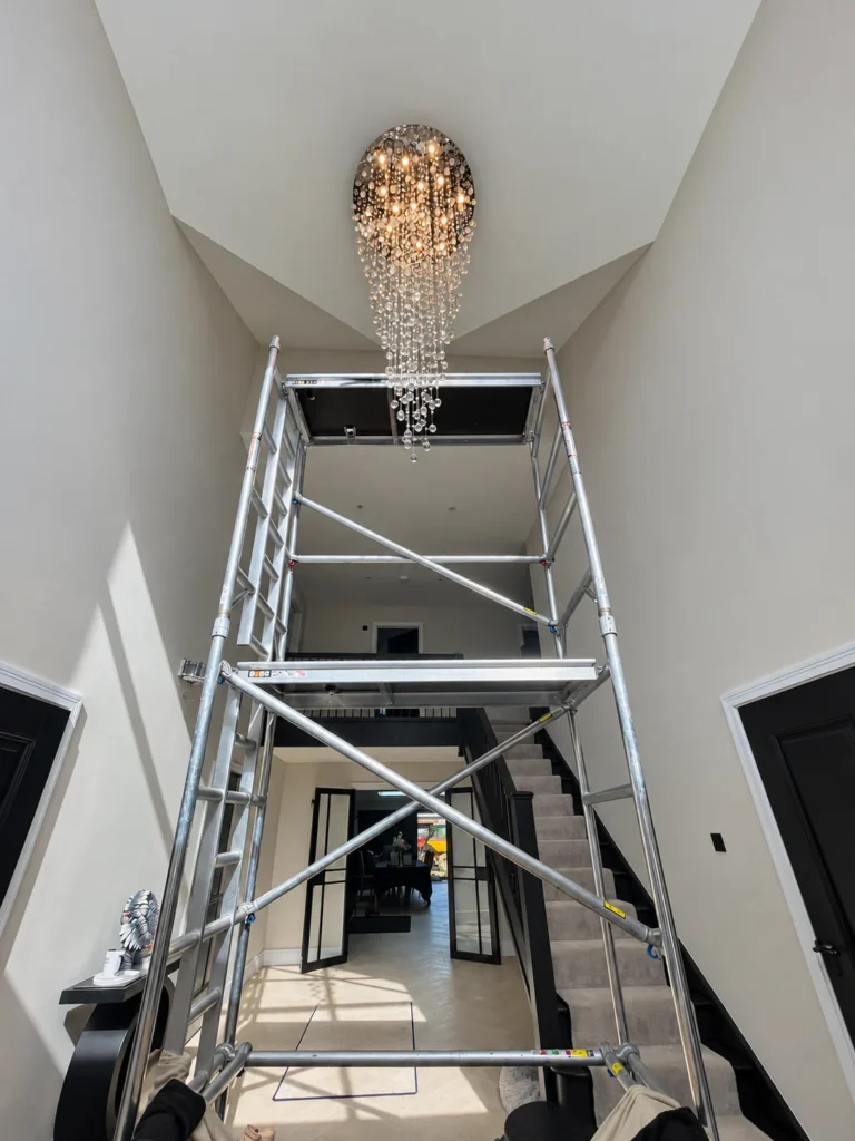 Access tower beneath a high stairwell chandelier