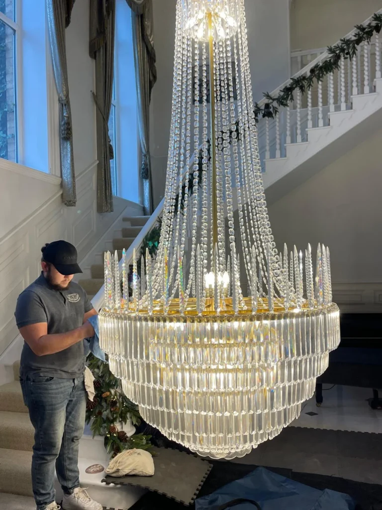 Rhys cleaning a large crystal chandelier