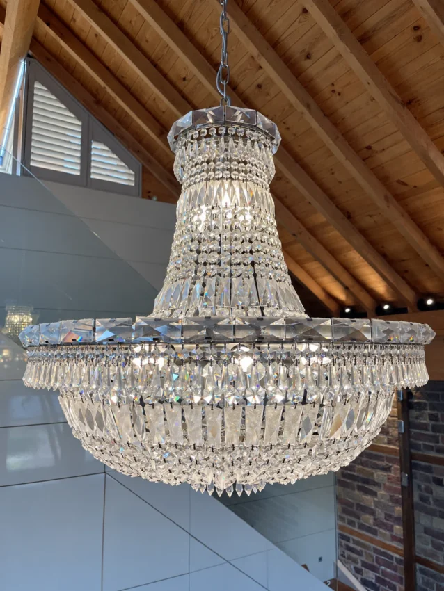 Tiered crystal chandelier beneath a timber ceiling